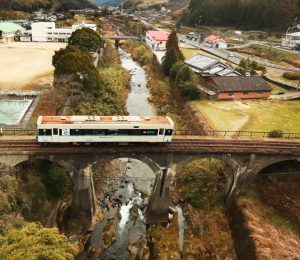 伸びやかなアーチを描く吉井川橋梁の上を走る松浦鉄道の車両＝佐世保市吉井町