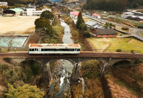 伸びやかなアーチを描く吉井川橋梁の上を走る松浦鉄道の車両＝佐世保市吉井町