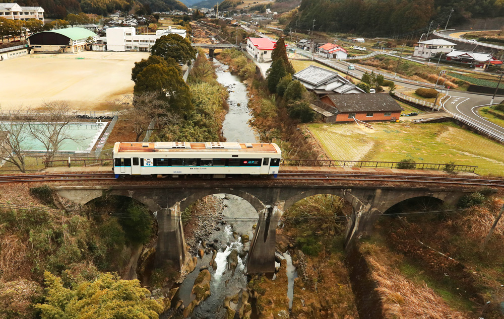 伸びやかなアーチを描く吉井川橋梁の上を走る松浦鉄道の車両＝佐世保市吉井町